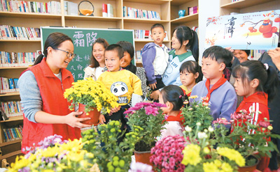 10月19日，在江蘇省如皋市城南街道肖陸村農(nóng)家書屋，小朋友賞菊花、學習霜降節(jié)氣習俗。徐 慧攝（人民視覺）